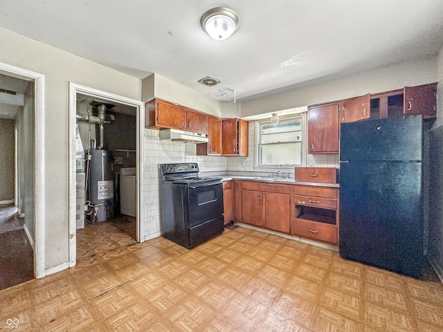 3505 N Emerson Ave, Indianapolis, IN 46218 - kitchen featuring black appliances, under cabinet range hood, gas water heater, light countertops, and brown cabinets