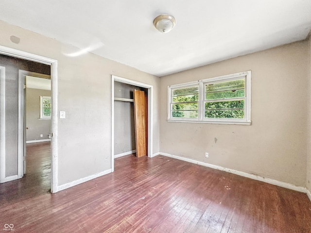 3505 N Emerson Ave, Indianapolis, IN 46218 - unfurnished bedroom with multiple windows, wood-type flooring, and a closet