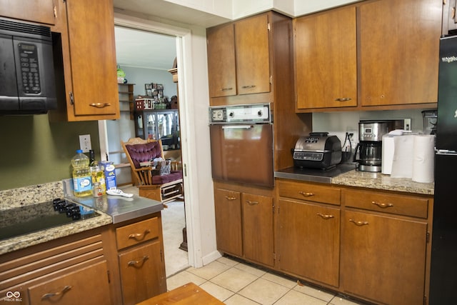 124 Georgton Ct, West Lafayette, IN 47906 - kitchen with black appliances, light tile patterned floors, and brown cabinetry
