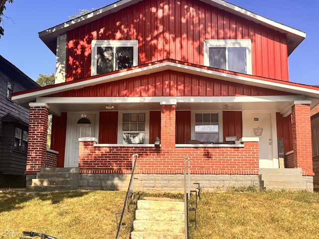 543 N Oakland Ave, Indianapolis, IN 46201 - view of front of house with a porch, a front yard, and brick siding