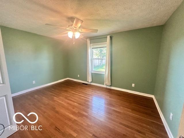 9490 N Keith Dr W, Columbus, IN 47203 - empty room with ceiling fan, wood finished floors, and a textured ceiling
