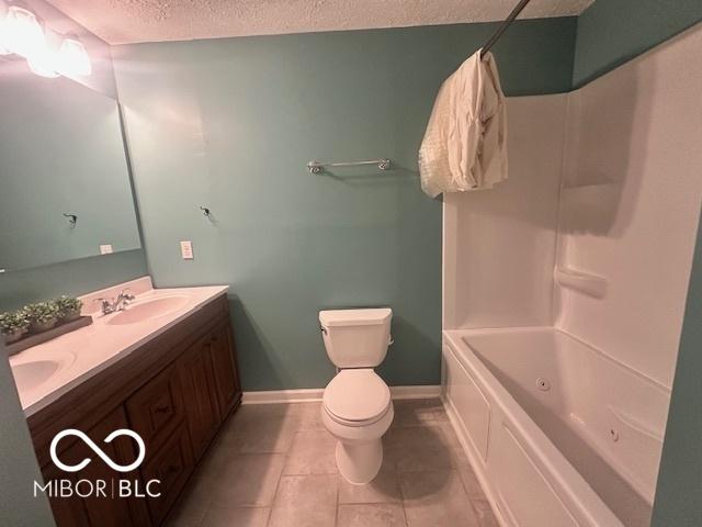 9490 N Keith Dr W, Columbus, IN 47203 - bathroom featuring double vanity, a textured ceiling, tile patterned flooring, and shower / tub combination