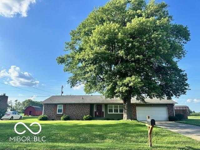9490 N Keith Dr W, Columbus, IN 47203 - ranch-style house featuring a front yard, driveway, and an attached garage