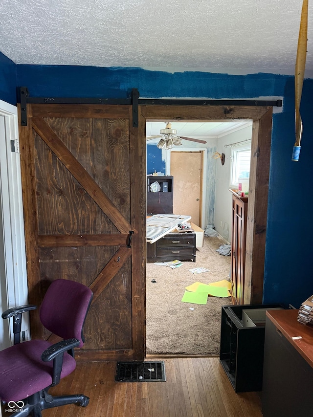 1918 14th St, Columbus, IN 47201 - hall with a barn door, wood-type flooring, and a textured ceiling