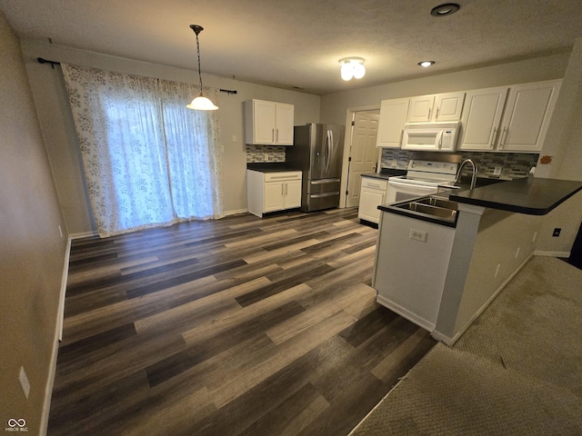 4293 Blue Spruce Ct, Greenwood, IN 46143 - kitchen with white appliances, dark countertops, a peninsula, decorative backsplash, and white cabinetry