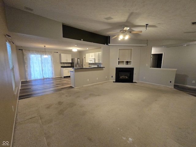4293 Blue Spruce Ct, Greenwood, IN 46143 - unfurnished living room with carpet, ceiling fan, and a fireplace with flush hearth