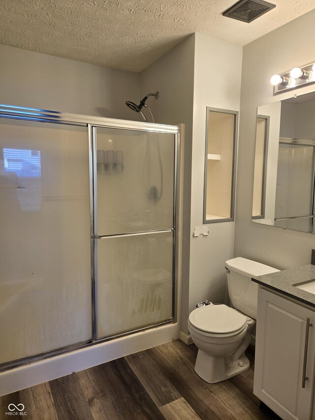 4293 Blue Spruce Ct, Greenwood, IN 46143 - bathroom featuring vanity, wood finished floors, a stall shower, and a textured ceiling