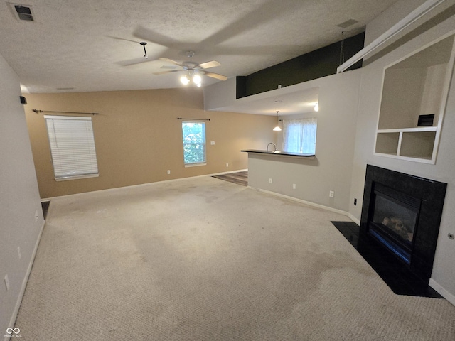 4293 Blue Spruce Ct, Greenwood, IN 46143 - unfurnished living room featuring a fireplace with flush hearth, carpet flooring, a ceiling fan, and a textured ceiling