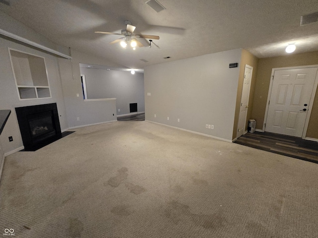 4293 Blue Spruce Ct, Greenwood, IN 46143 - unfurnished living room featuring ceiling fan, carpet floors, a fireplace with flush hearth, and vaulted ceiling