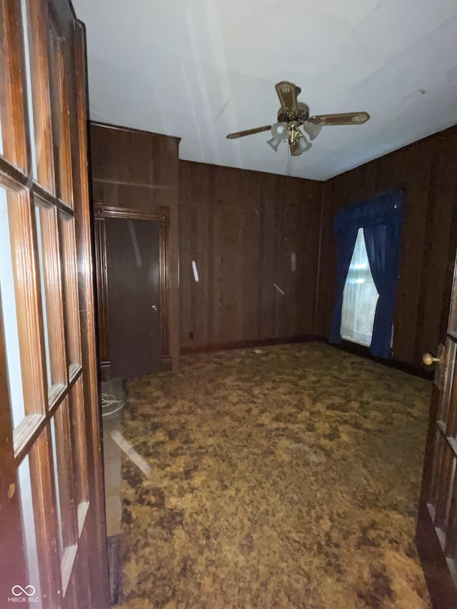 3220 E New York St, Indianapolis, IN 46201 - spare room featuring a ceiling fan, carpet flooring, and wooden walls