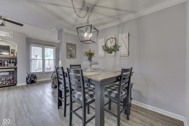 7444 Melanie Ln, Indianapolis, IN 46217 - dining room featuring wood finished floors, a chandelier, a textured ceiling, crown molding, and ceiling fan