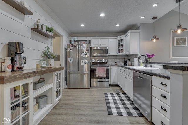 7444 Melanie Ln, Indianapolis, IN 46217 - kitchen with appliances with stainless steel finishes, open shelves, a peninsula, dark countertops, and white cabinetry