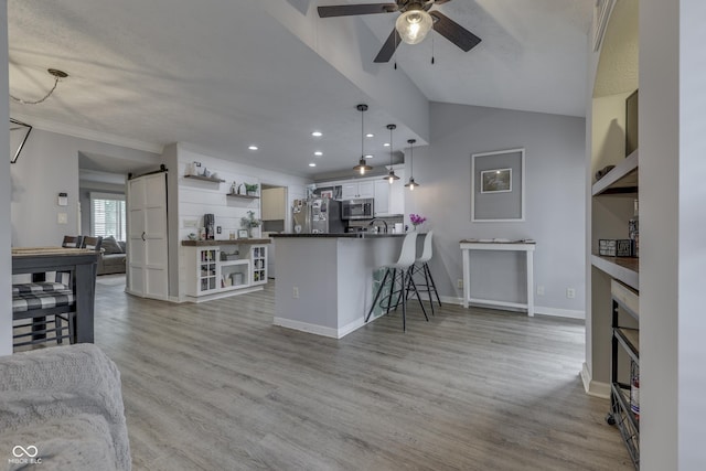 7444 Melanie Ln, Indianapolis, IN 46217 - kitchen with stainless steel appliances, open shelves, a ceiling fan, open floor plan, and vaulted ceiling