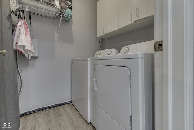 7444 Melanie Ln, Indianapolis, IN 46217 - laundry area with cabinet space, washing machine and clothes dryer, and light wood-style flooring