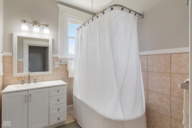 3055 N Washington Blvd, Indianapolis, IN 46205 - bathroom with tile walls, curtained shower, vanity, and wainscoting