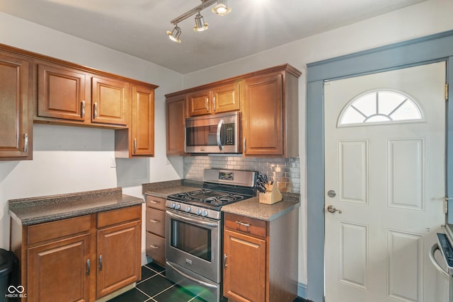 3055 N Washington Blvd, Indianapolis, IN 46205 - kitchen featuring appliances with stainless steel finishes, dark countertops, and brown cabinetry