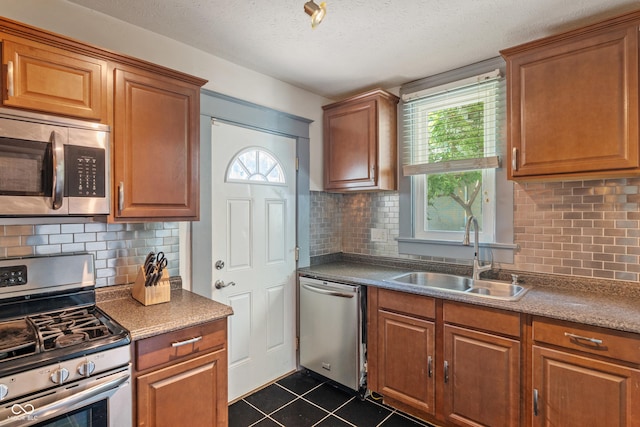 3055 N Washington Blvd, Indianapolis, IN 46205 - kitchen with stainless steel appliances, dark tile patterned flooring, backsplash, brown cabinets, and a textured ceiling