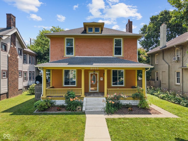 3055 N Washington Blvd, Indianapolis, IN 46205 - traditional style home featuring covered porch, a front lawn, roof with shingles, and cooling unit