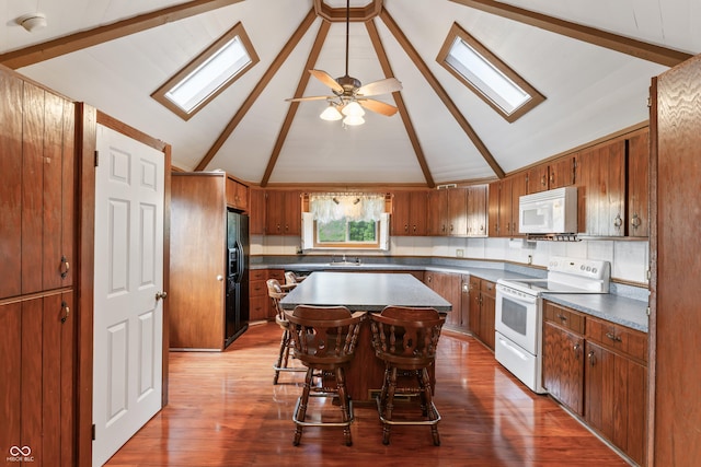 19120 Tomlinson Rd, Westfield, IN 46074 - kitchen with white appliances, a skylight, brown cabinets, and a kitchen island