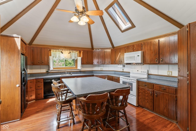 19120 Tomlinson Rd, Westfield, IN 46074 - kitchen featuring black appliances, a skylight, dark countertops, and brown cabinets