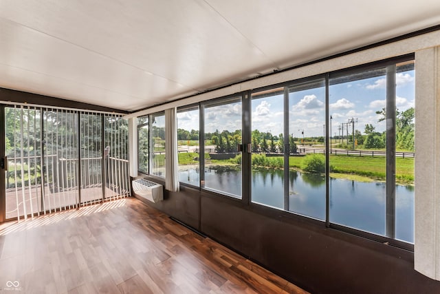 19120 Tomlinson Rd, Westfield, IN 46074 - unfurnished sunroom with healthy amount of natural light, a wall mounted AC, a water view, wood finished floors, and vaulted ceiling