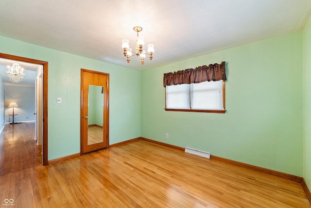2635 15th St, Columbus, IN 47201 - empty room with a chandelier, baseboard heating, and light wood-style flooring