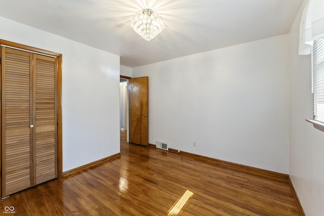 2635 15th St, Columbus, IN 47201 - unfurnished bedroom with a chandelier, wood finished floors, and a closet