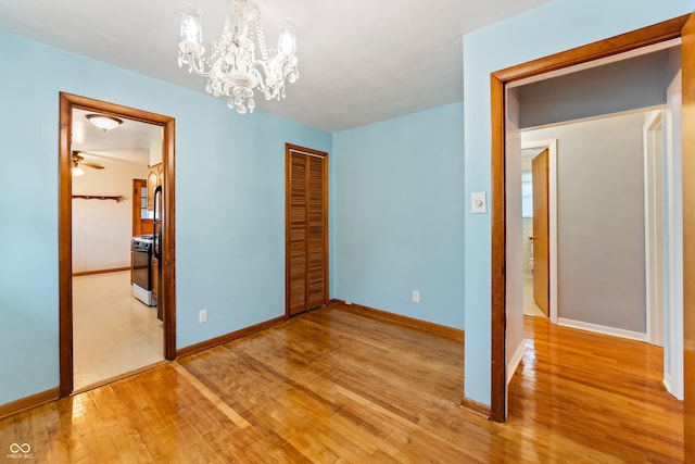 2635 15th St, Columbus, IN 47201 - unfurnished bedroom featuring wood finished floors, a chandelier, a closet, and connected bathroom