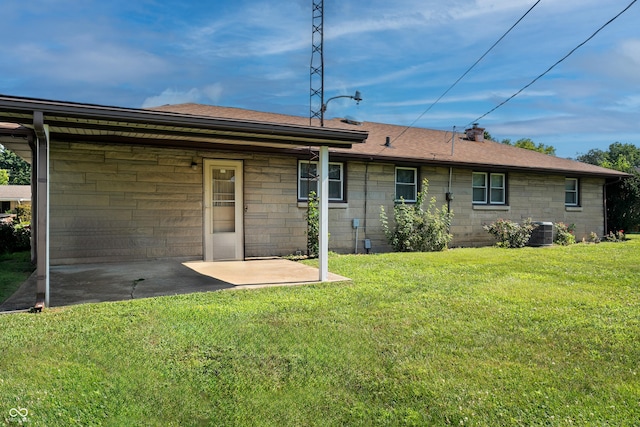 2635 15th St, Columbus, IN 47201 - rear view of property with a yard, a patio, concrete block siding, and roof with shingles