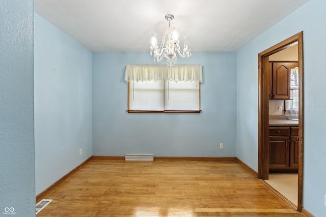 2635 15th St, Columbus, IN 47201 - unfurnished dining area with a chandelier and light wood finished floors