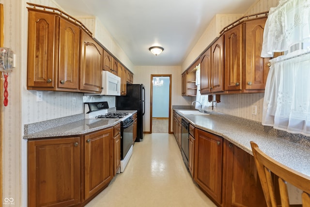 2635 15th St, Columbus, IN 47201 - kitchen with black appliances, wallpapered walls, brown cabinetry, and light countertops