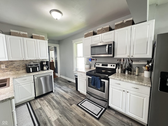 215 N Main St, Batesville, IN 47006 - kitchen with stainless steel appliances, light countertops, tasteful backsplash, white cabinets, and light wood-type flooring