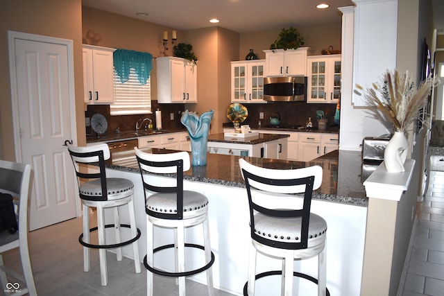 5817 Mustang Ter, Plainfield, IN 46168 - kitchen with stainless steel microwave, a center island, glass insert cabinets, tasteful backsplash, and white cabinets