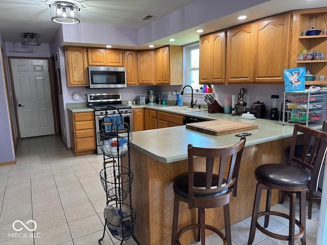 1214 Lindsey Ln, Lebanon, IN 46052 - kitchen with appliances with stainless steel finishes, light tile patterned floors, a peninsula, brown cabinets, and light countertops