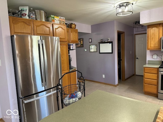 1214 Lindsey Ln, Lebanon, IN 46052 - kitchen with stainless steel appliances, light tile patterned floors, brown cabinets, and light countertops