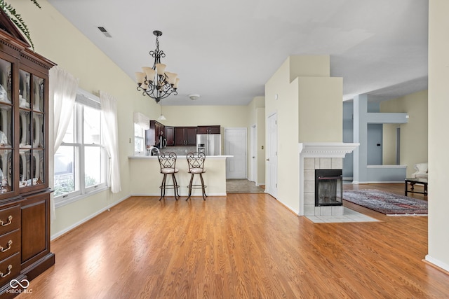 10721 Chesapeake Dr S, Indianapolis, IN 46236 - living room with a chandelier, light wood-style flooring, and a tile fireplace