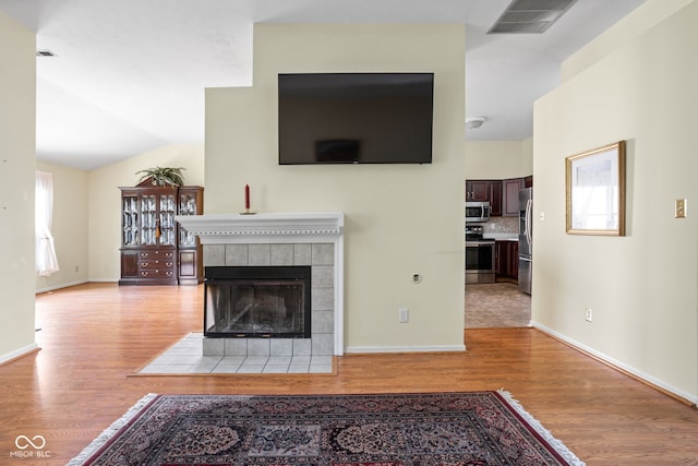 10721 Chesapeake Dr S, Indianapolis, IN 46236 - living area with light wood-type flooring, a fireplace, and vaulted ceiling