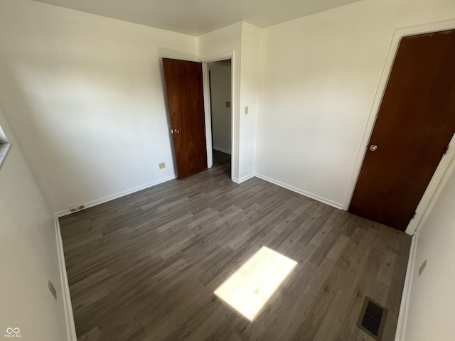1615 S 9th Ave, Beech Grove, IN 46107 - unfurnished bedroom with dark wood-style flooring and baseboards