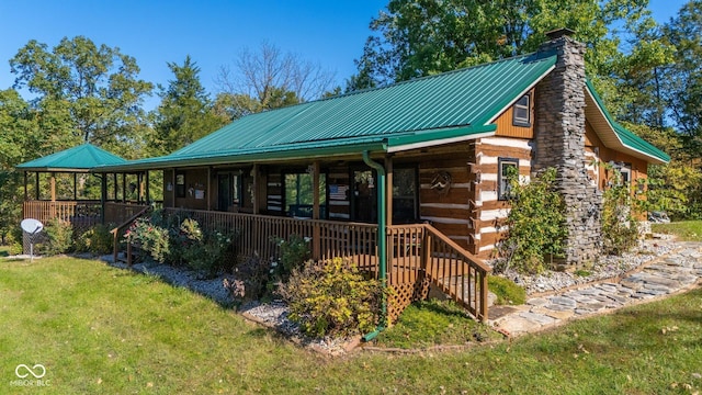 8701 E Splinter Ridge Rd, Madison, IN 47250 - view of front of home with a chimney, a front lawn, log siding, and a metal roof