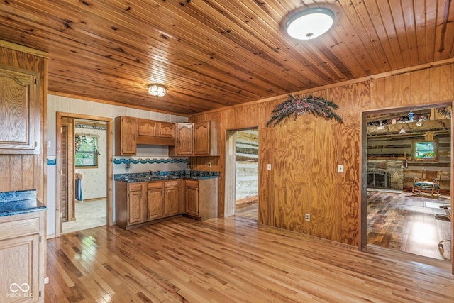 8701 E Splinter Ridge Rd, Madison, IN 47250 - kitchen with wooden walls, light wood-style flooring, wooden ceiling, brown cabinets, and dark countertops