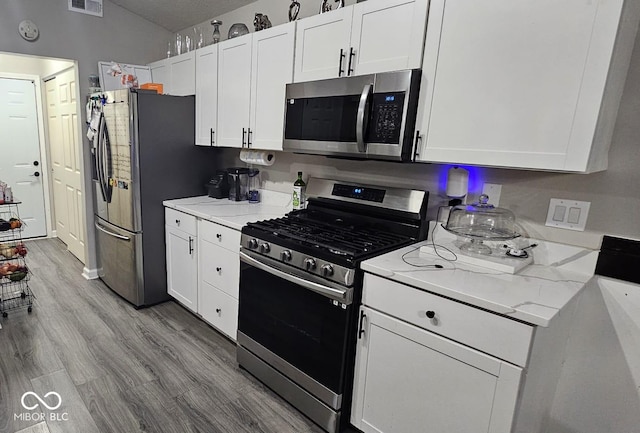 5648 Hyacinth Way, Indianapolis, IN 46254 - kitchen with stainless steel appliances, white cabinetry, wood finished floors, and light stone counters