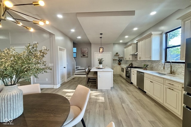 1440 S New Jersey St, Indianapolis, IN 46225 - kitchen featuring cream cabinetry, appliances with stainless steel finishes, a breakfast bar, light wood-type flooring, and a center island