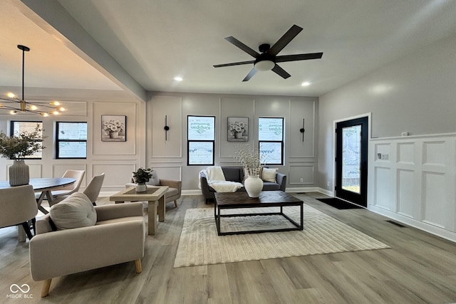 1440 S New Jersey St, Indianapolis, IN 46225 - living room featuring a decorative wall, a chandelier, wood finished floors, plenty of natural light, and a ceiling fan