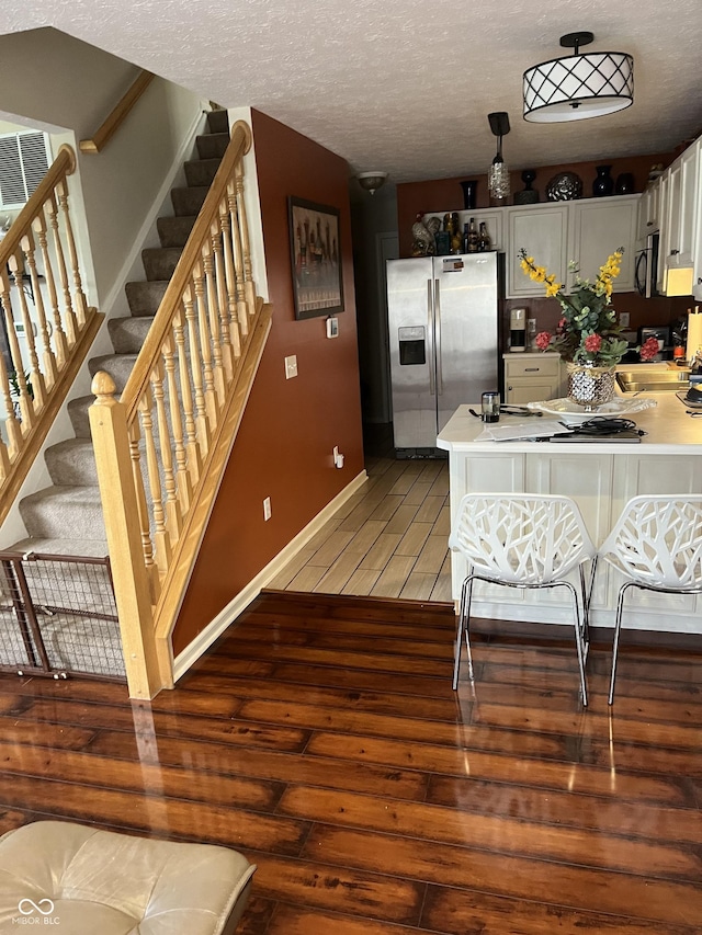 5931 Marina View Ln, Indianapolis, IN 46237 - kitchen featuring appliances with stainless steel finishes, light wood-style floors, light countertops, white cabinetry, and a textured ceiling