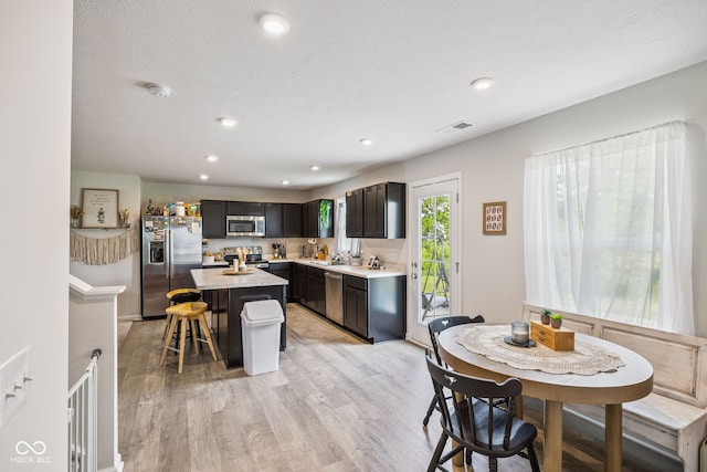 197 N Fairfield Dr, Danville, IN 46122 - kitchen featuring appliances with stainless steel finishes, a breakfast bar area, light countertops, light wood-style flooring, and a center island