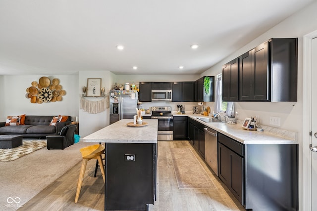 197 N Fairfield Dr, Danville, IN 46122 - kitchen with appliances with stainless steel finishes, a center island, a kitchen bar, open floor plan, and light wood-type flooring