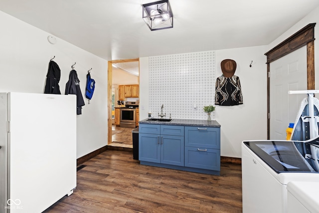 631 S State Road 39, Danville, IN 46122 - kitchen featuring electric range, freestanding refrigerator, washing machine and clothes dryer, blue cabinetry, and dark wood-style flooring