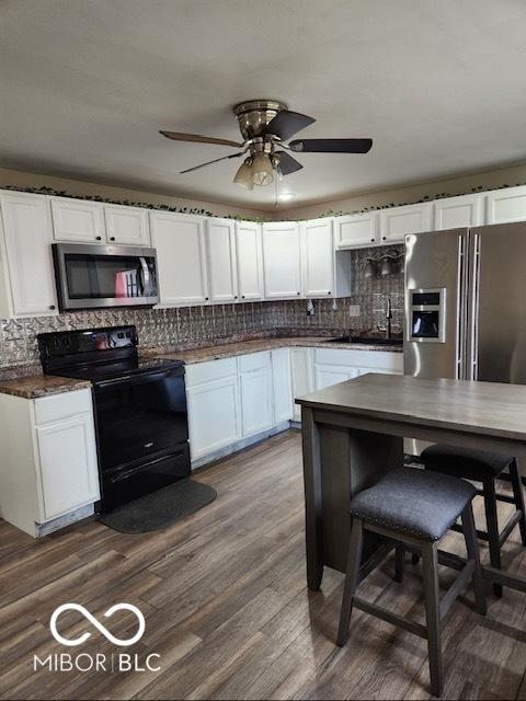 608 High School Dr, Edinburgh, IN 46124 - kitchen featuring appliances with stainless steel finishes, ceiling fan, decorative backsplash, and white cabinetry