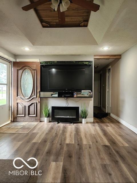608 High School Dr, Edinburgh, IN 46124 - unfurnished living room with wood finished floors, a glass covered fireplace, a ceiling fan, and recessed lighting