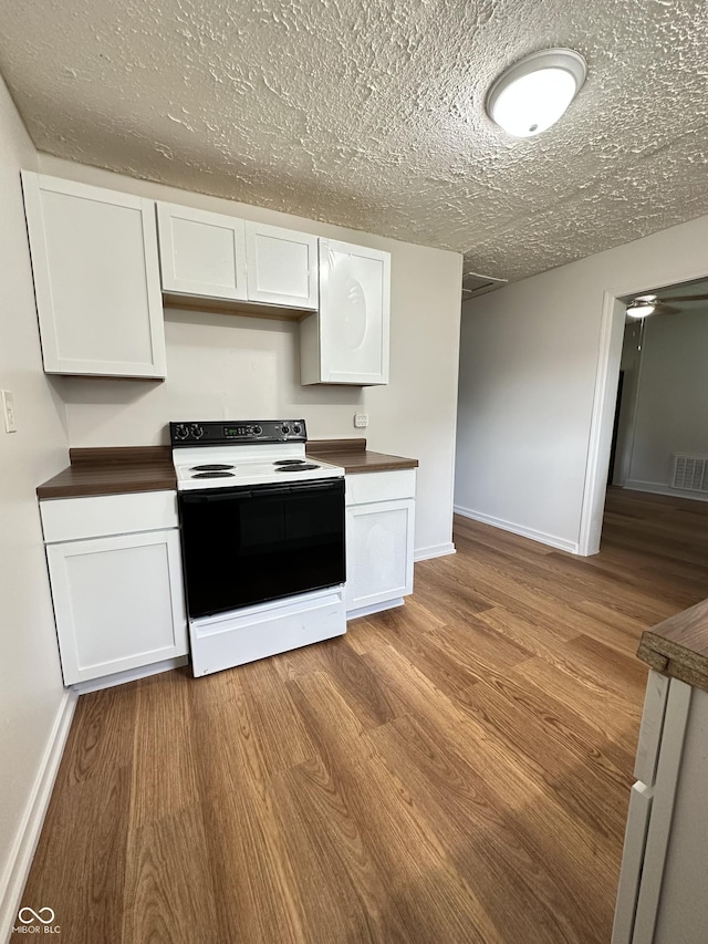 107 S Nebraska St, North Salem, IN 46165 - kitchen with white electric range, dark countertops, white cabinets, and a textured ceiling